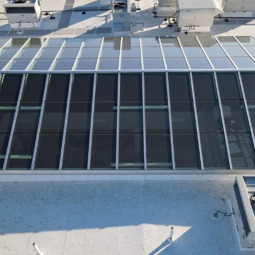 Large glass roof over commercial building by Apollo Industries