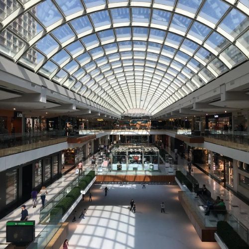 Iniside of mall with view of arced glass roof by Apollo Industries